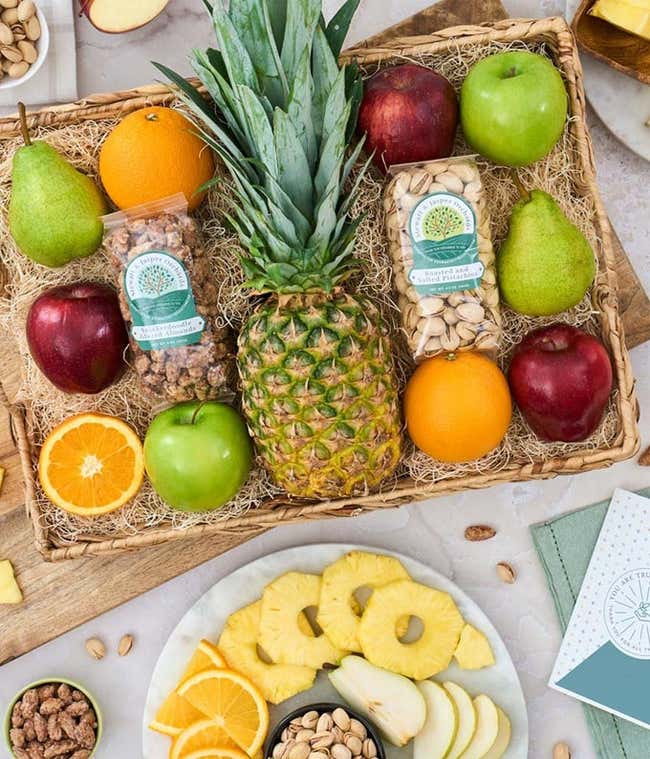 Gift Basket with a pineapple, red apples, green apples, oranges, pears, snickerdoodle glazed almonds, and pisatchios