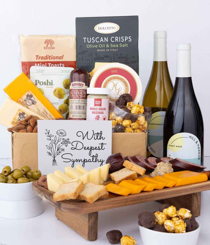 An abundant gift box filled with California Pinot Noir and Chardonnay, assorted crackers, three cheeses, summer sausage, and snacks with a Sympathy Card. 