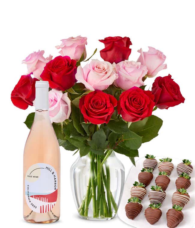A mixed bouquet of 1 dozen red and blush roses in a clear vase is paired with a bottle of Hill &amp; Harbor Ros&eacute; and 12 chocolate-covered strawberries.