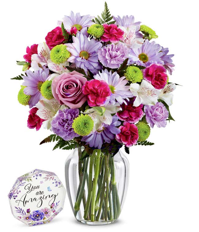 A bouquet featuring lavender daisies, lavender roses, hot pink mini carnations, lavender carnations, white alstroemeria, and green button poms, with an optional vase.