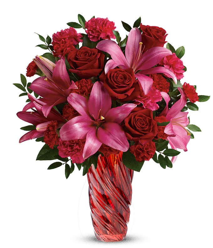 Red Roses, Dark Pink Lilies, and Hot Pink Carnations in a Tall Red Swirl Vase