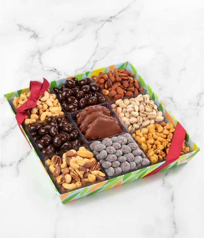 A colorful gift tray featuring an assortment of nuts and chocolates, including roasted salted cashews, pistachios, mixed nuts, almonds, butter toffee peanuts, dark chocolate almonds, chocolate toffee dusted almonds, and four sea salt caramels.