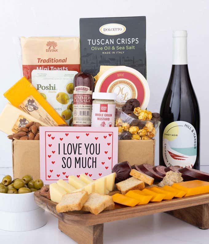 A luxurious gift box with two bottles of Hill & Harbor wine (red & white), three cheeses, gourmet crackers, summer sausage, marinated olives, smoked almonds, stone-ground mustard, chocolate-covered, and a pink 'I Love You So Much' card