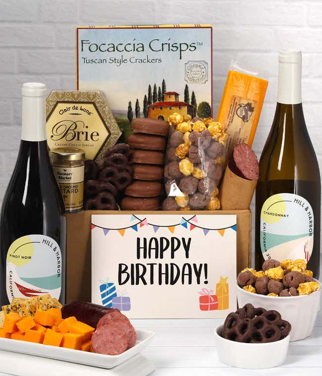 A gift set featuring two bottles of Hill &amp; Harbor wine - white and red, focaccia crisps, two cheeses, mustard, summer sausage, caramel popcorn, chocolate pretzels, six chocolate-covered Oreos and a Birthday card to complete the gourmet experience.