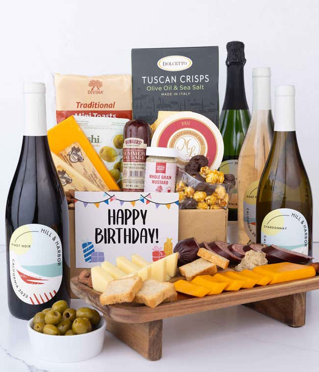 A wine and cheese gift set featuring 4 bottles of California wine - sparkling, ros&eacute;, white, and red. Includes a variety of gourmet cheeses, crackers, olives, almonds, summer sausage, and condiments topped with a Happy Birthday Card.